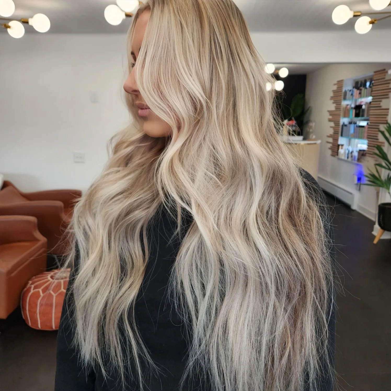 Long icy platinum waves photographed on the Hair Garden floor, leather chairs and mirrors behind.